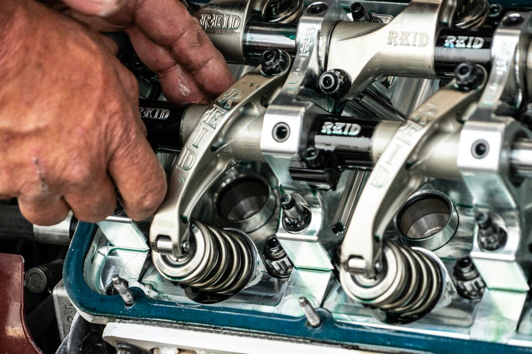 Mechanic inspecting a car engine in a service bay