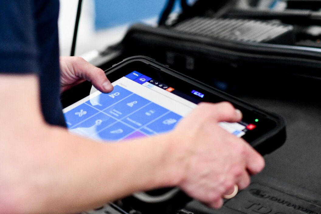 Technician using a diagnostic scanner on a vehicle