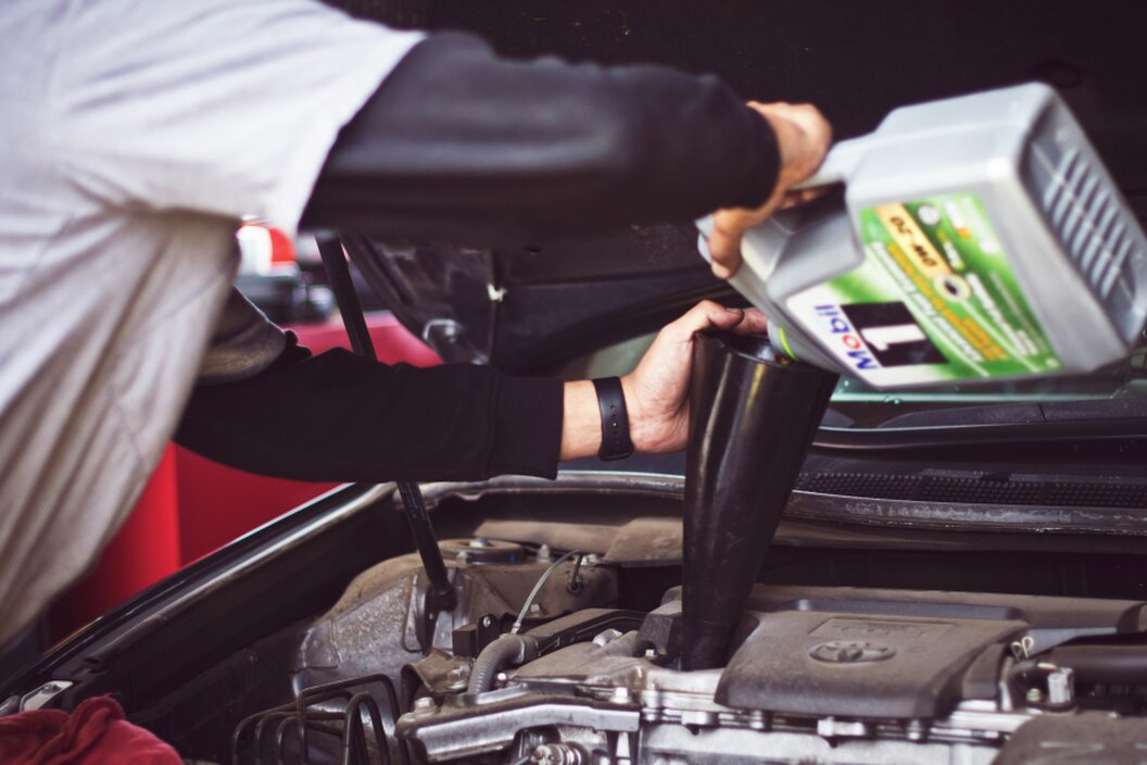 Oil being poured into a car engine during maintenance