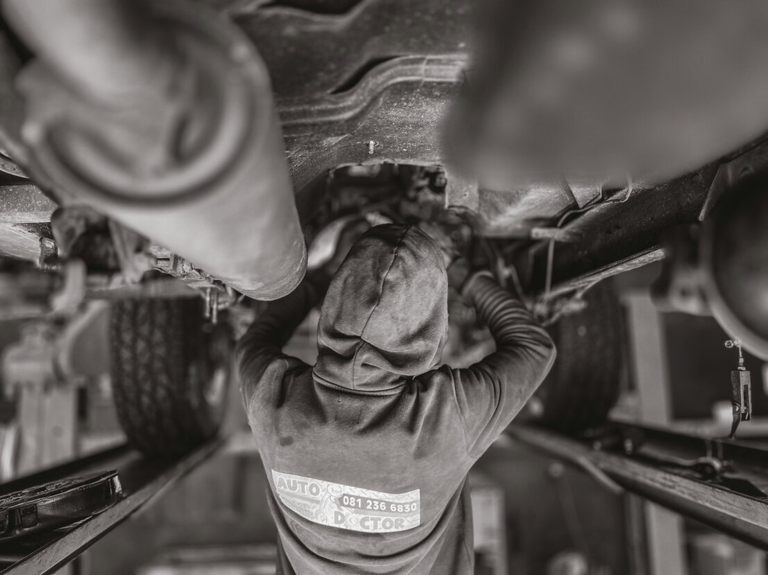 Mechanic working on a vehicle at the EPCarGuy service bay